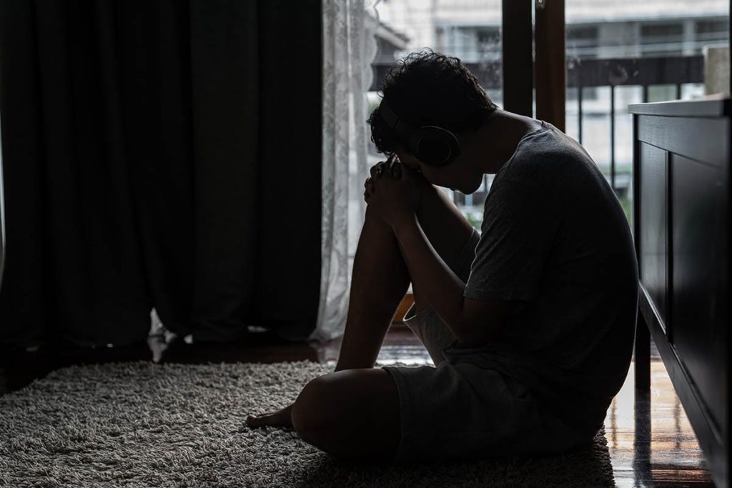 person with head down considering the opioid epidemic