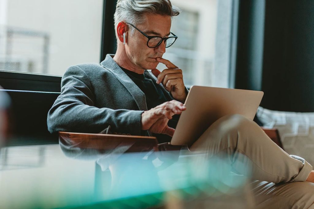 man on laptop learning about the causes of addiction
