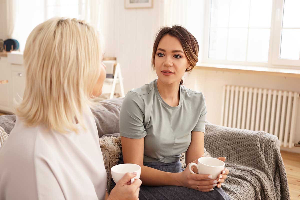 woman in grey shirt on couch learning about how to talk about addiction