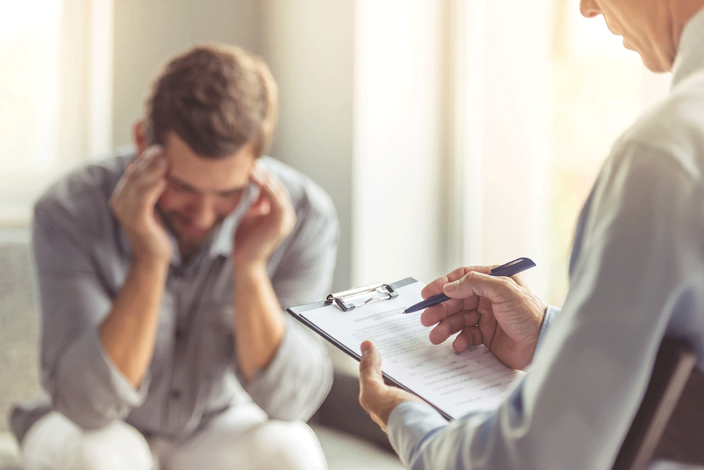 man with head in hands considers mental health and addiction