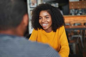 woman in yellow shirt talks with therapist about a life skills training program in North Carolina