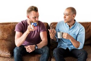 two men talk over coffee in motivational interviewing therapy 