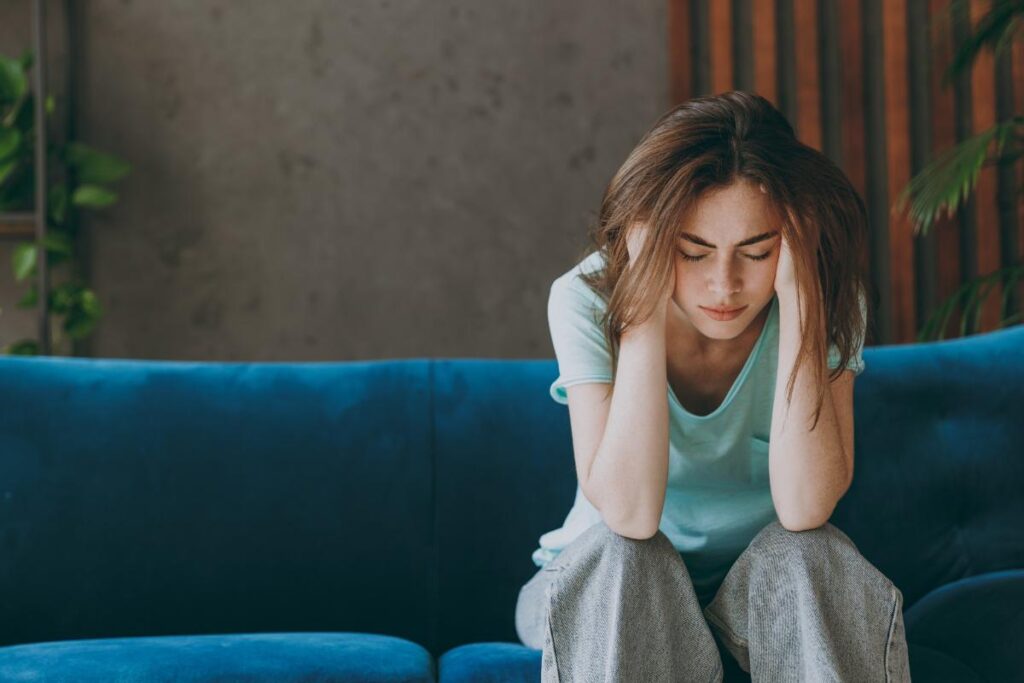 woman with head in hands considers signs of depression