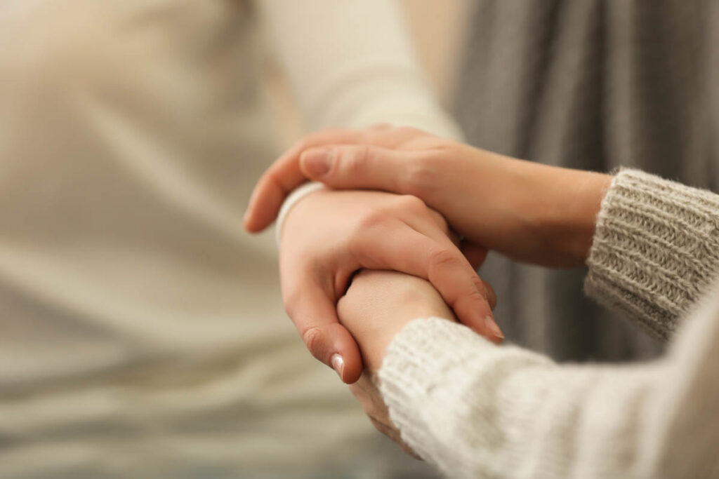 a person comforts another who is wondering how to get off fentanyl while holding their hand