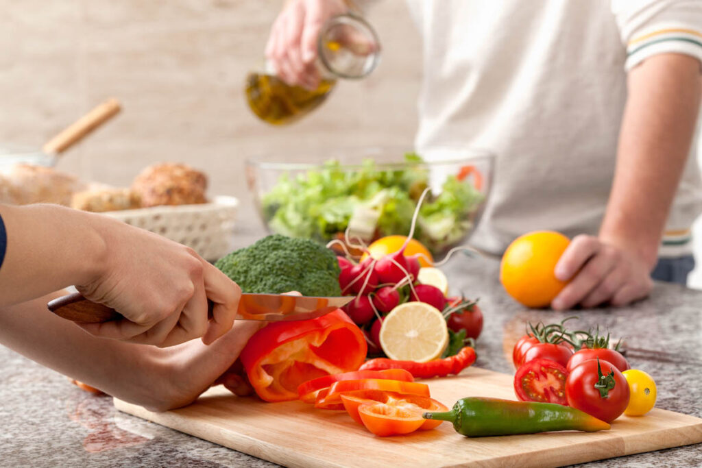 a person cuts up veggies to show nutrition as therapy