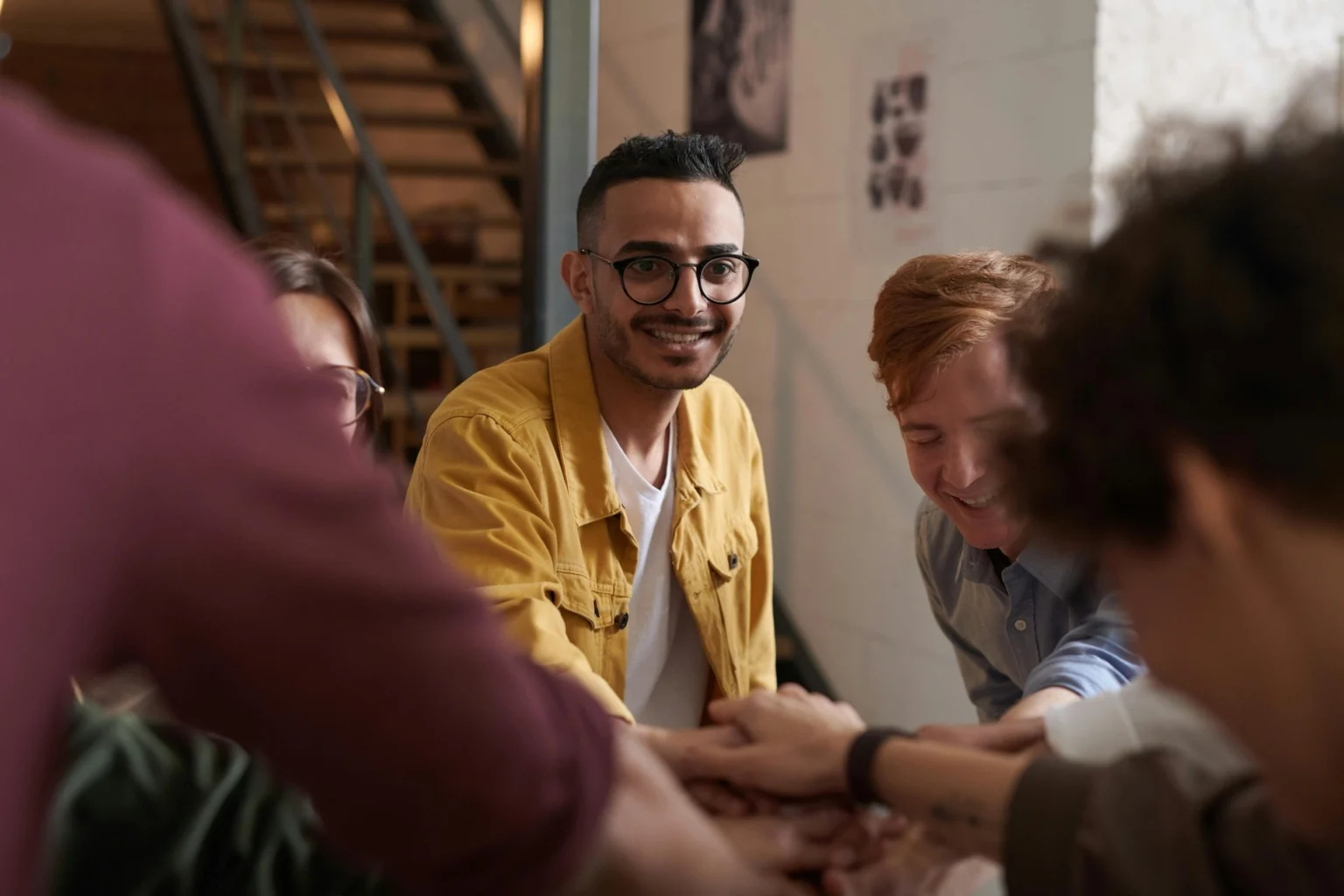 A man in a yellow jacket smiling during a group therapy session during Day Intensive Outpatient Program in Wilmington, NC.