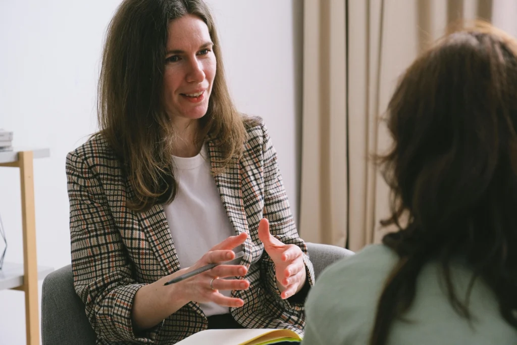 Alt: A female addiction counselor in a blazer leading an individual therapy session during daytime IOP in Wilmington, NC.